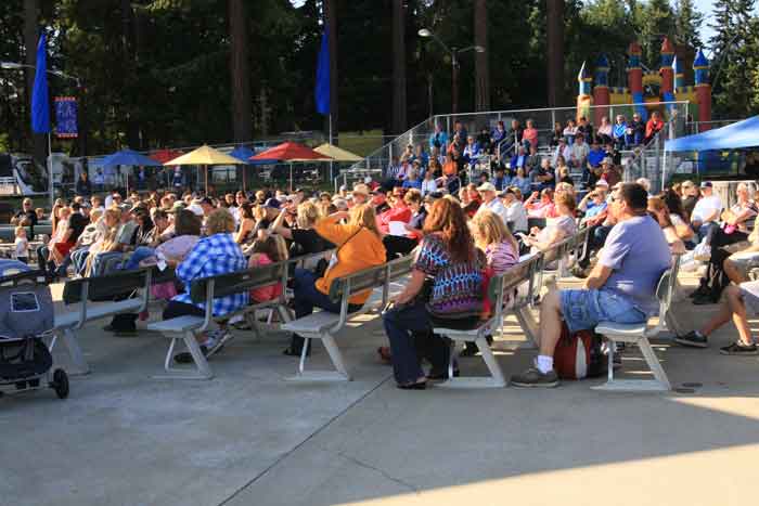 People sitting along the West Stage